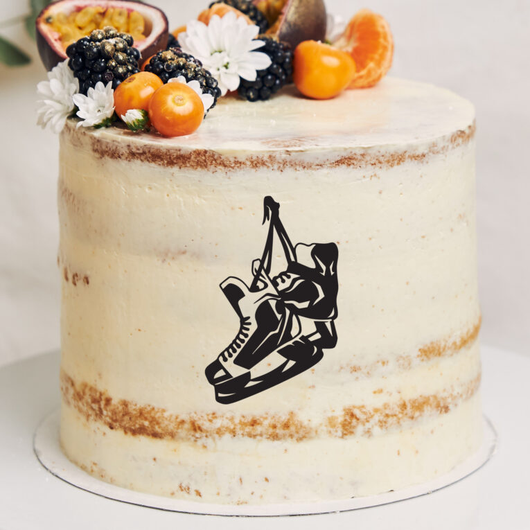 White cake with berries and passionfruits next to a plant behind a white background