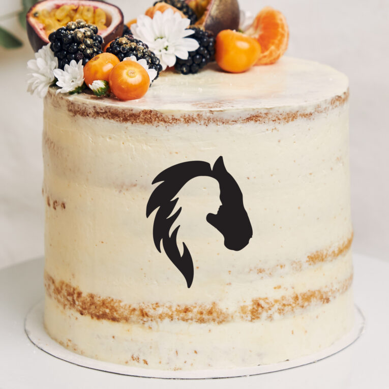 White cake with berries and passionfruits next to a plant behind a white background