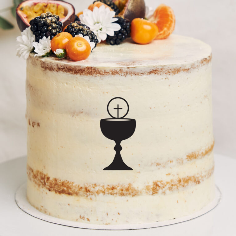 White cake with berries and passionfruits next to a plant behind a white background