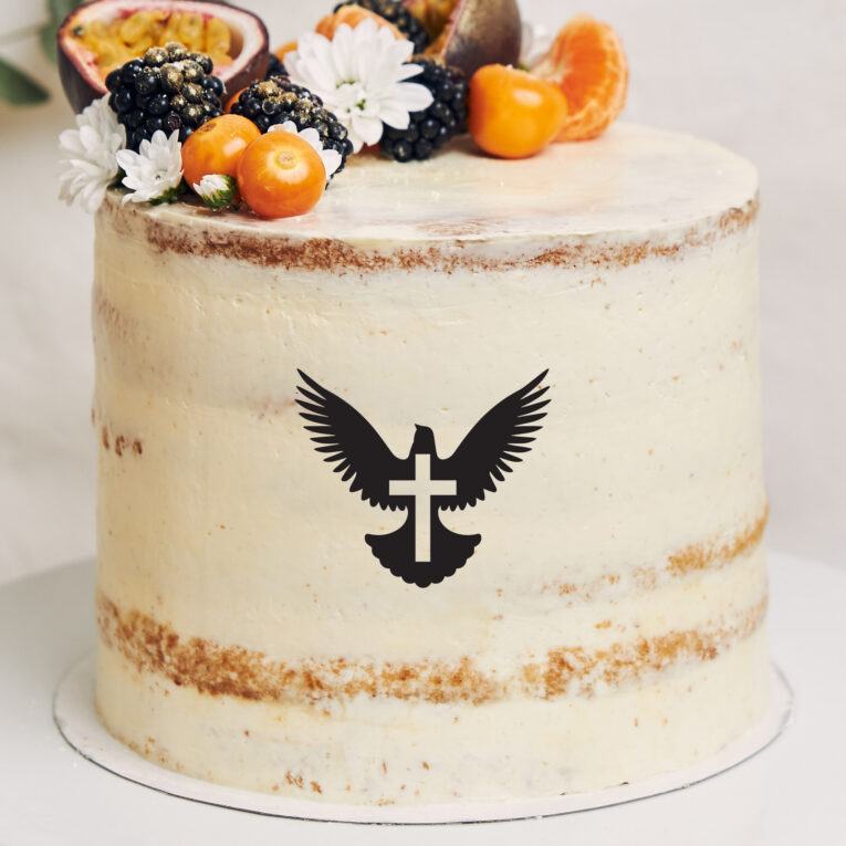 White cake with berries and passionfruits next to a plant behind a white background