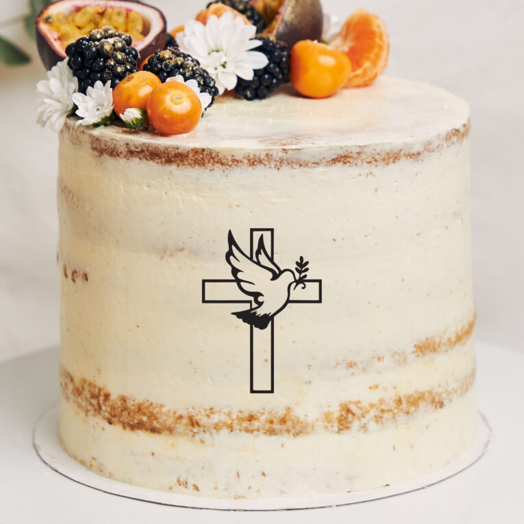 White cake with berries and passionfruits next to a plant behind a white background